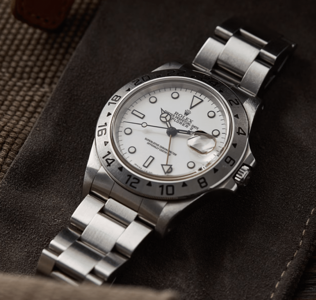 a silver watch with a white face